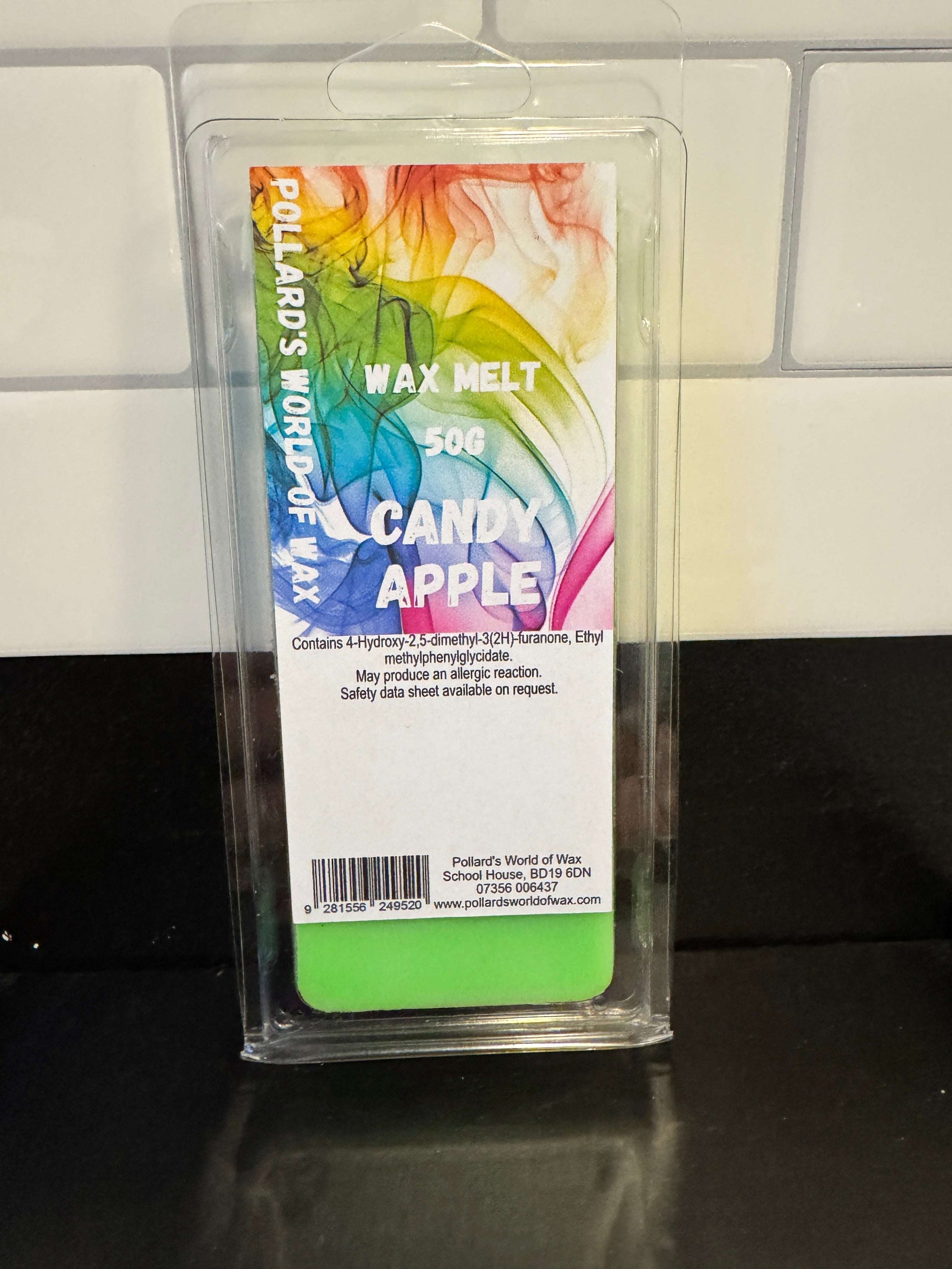 Candle melt package with colorful label on a tiled floor